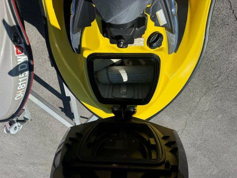 Slide: The Image of Yellow Sea-Doo jet ski with open storage compartment, parked on a trailer. - 11