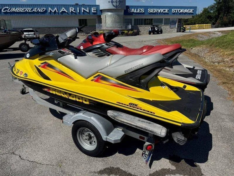 Slide: The Image of Two Sea-Doo jet skis on a trailer in front of a marine shop. - 2