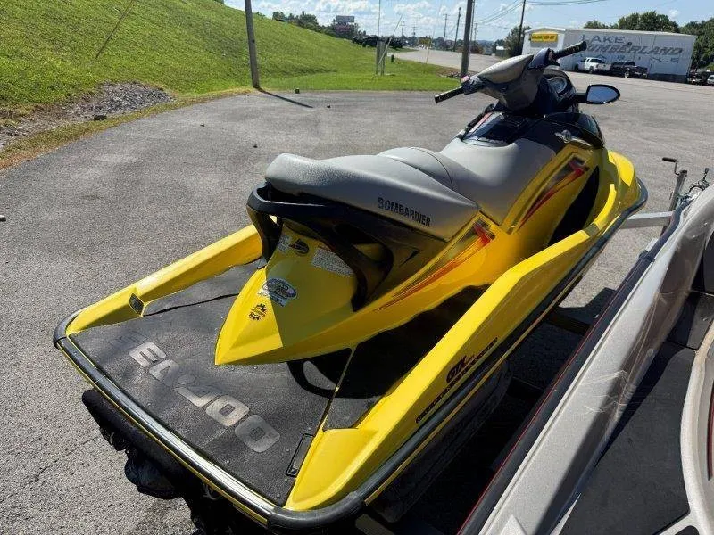 Slide: The Image of A yellow Sea-Doo jet ski is on a trailer in a parking lot. - 5