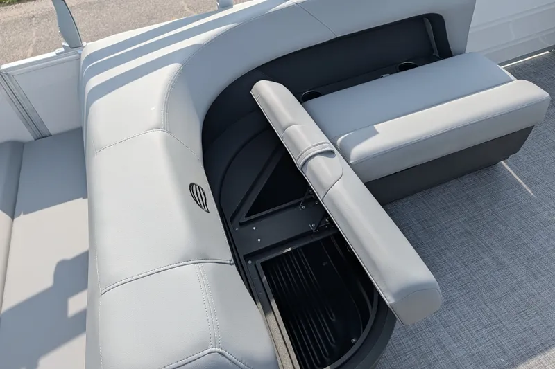 Slide: The Image of 2027 Sun Tracker Party Barge 18 DLX with open storage compartment and gray seating. - 19