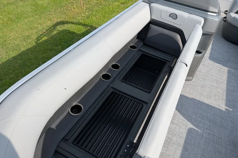 Slide: The Image of 2027 Sun Tracker Party Barge 18 DLX seating area with cup holders and storage compartments. - 17
