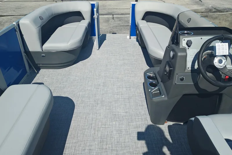 Slide: The Image of 2027 Sun Tracker Party Barge 16 DLX interior with gray seating and steering console. - 14