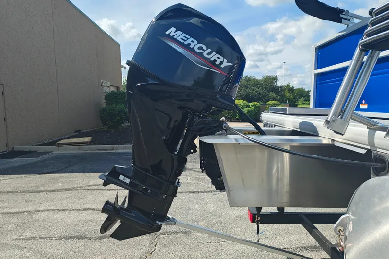 Slide: The Image of 2027 Sun Tracker Party Barge 16 DLX with Mercury outboard motor in a parking lot. - 24