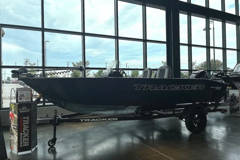 The Image of A 2027 Tracker Pro Guide V-16 SC boat on a trailer in a showroom. - 0