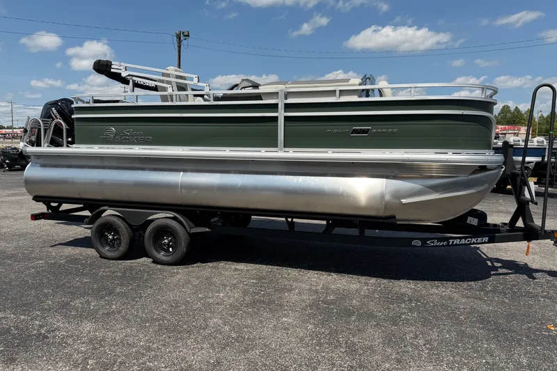The Image of 2027 Sun Tracker Fishin' Barge 20 DLX pontoon boat on trailer, outdoors. - 0