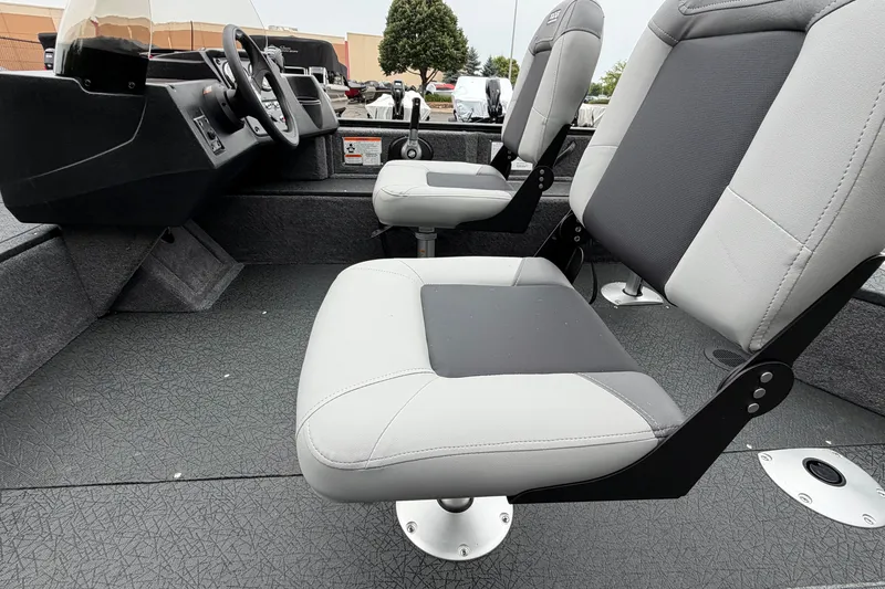 Slide: The Image of Interior of 2027 Tracker Pro Guide V-16 SC boat with gray seating and steering console. - 18