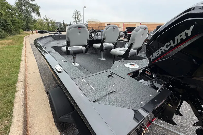 Slide: The Image of 2027 Tracker Pro Guide V-16 SC fishing boat with Mercury engine, parked on a paved road. - 14