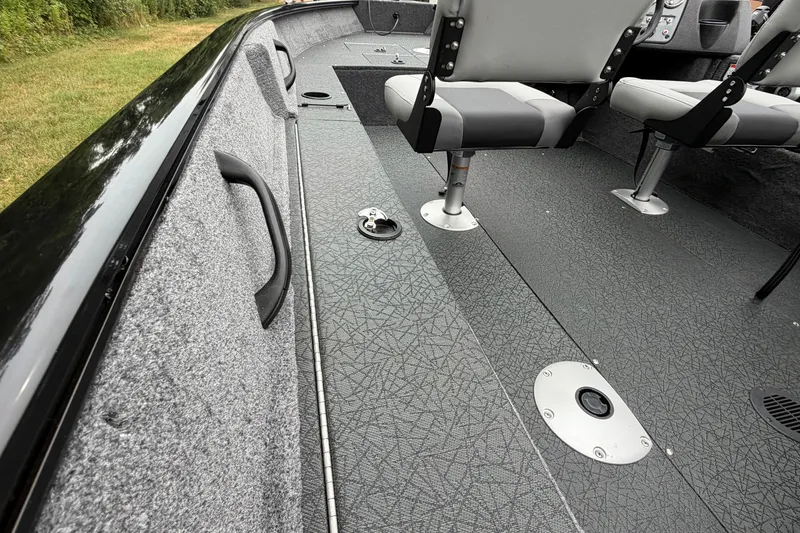 Slide: The Image of 2027 Tracker Pro Guide V-16 SC boat interior with gray seating and textured flooring. - 15