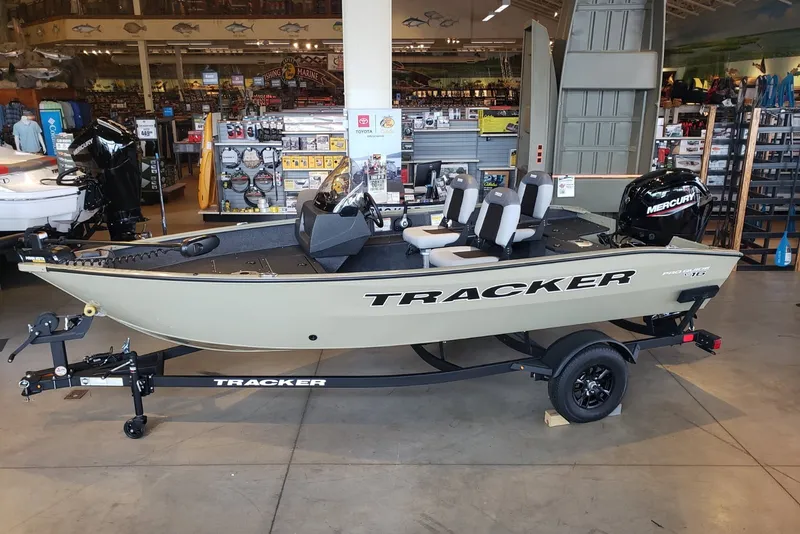The Image of 2027 Tracker Pro Guide V-16 SC fishing boat displayed in a showroom. - 0