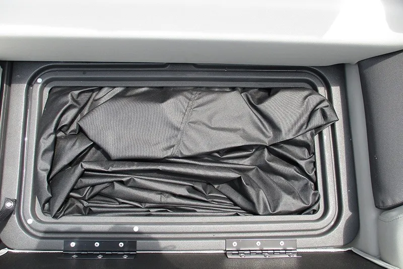 Slide: The Image of Storage compartment of 2027 Sun Tracker Fishin' Barge 20 DLX with black fabric lining. - 26