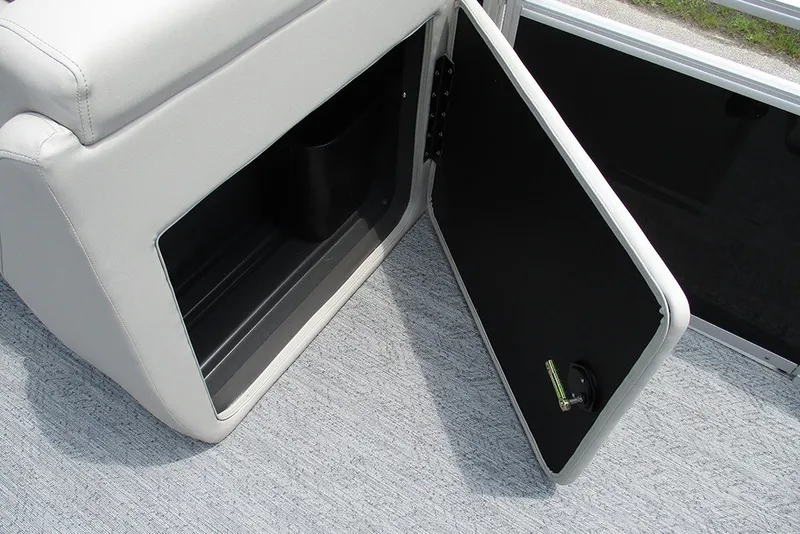 Slide: The Image of 2027 Sun Tracker Fishin' Barge 20 DLX storage compartment with open door on carpeted floor. - 22