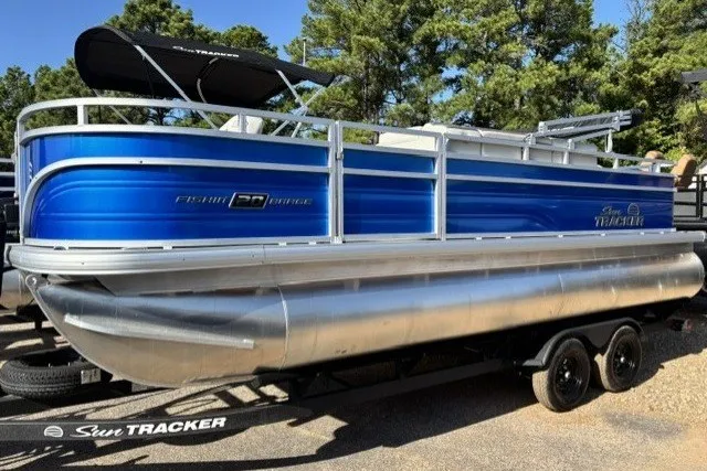 The Image of 2027 Sun Tracker Fishin' Barge 20 DLX pontoon boat on trailer, blue and silver design. - 0