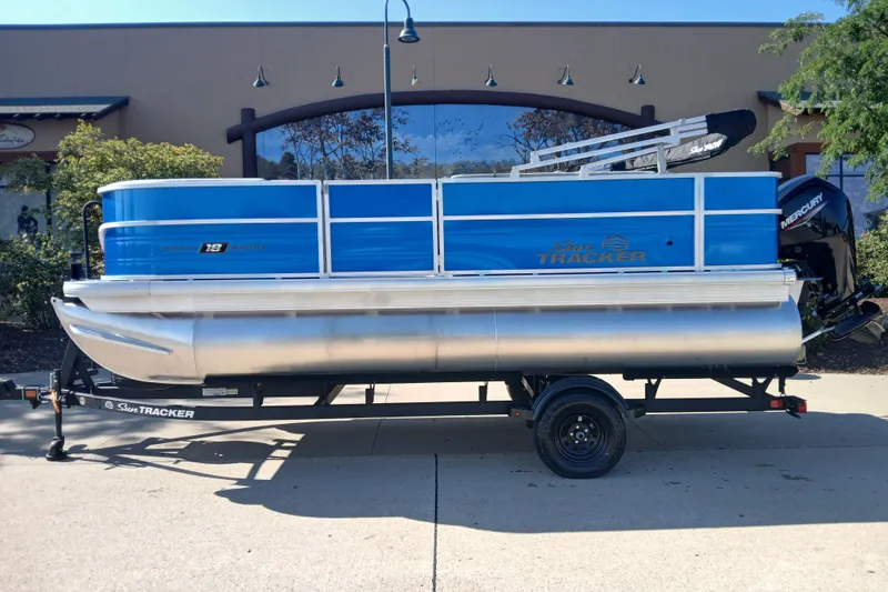 The Image of 2027 Sun Tracker Party Barge 18 DLX pontoon boat on trailer, parked outdoors. - 0