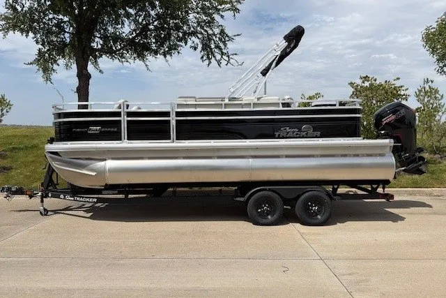The Image of 2027 Sun Tracker Fishin' Barge 20 DLX pontoon boat on trailer, parked outdoors. - 47