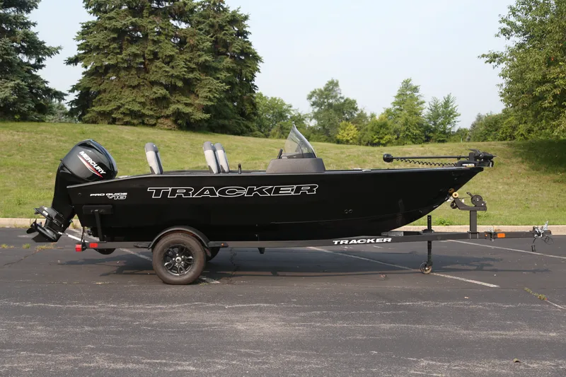 The Image of 2027 Tracker Pro Guide V-16 SC boat on trailer, parked outdoors. - 0