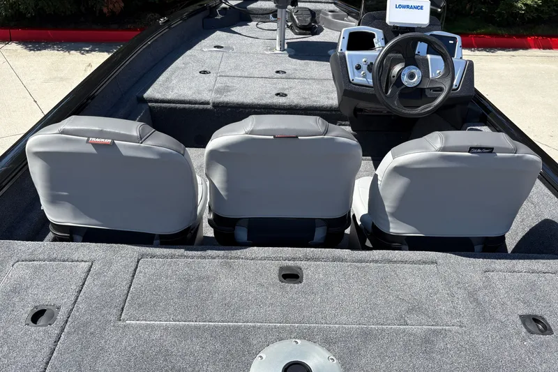 Slide: The Image of 2027 Tracker Pro Team 175 Crappie Edition boat interior with three gray seats and steering console. - 16