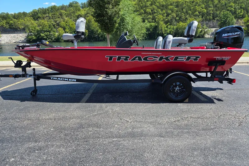 The Image of 2027 Tracker Pro Team 175 Crappie Edition boat, red, parked near a scenic lake. - 0