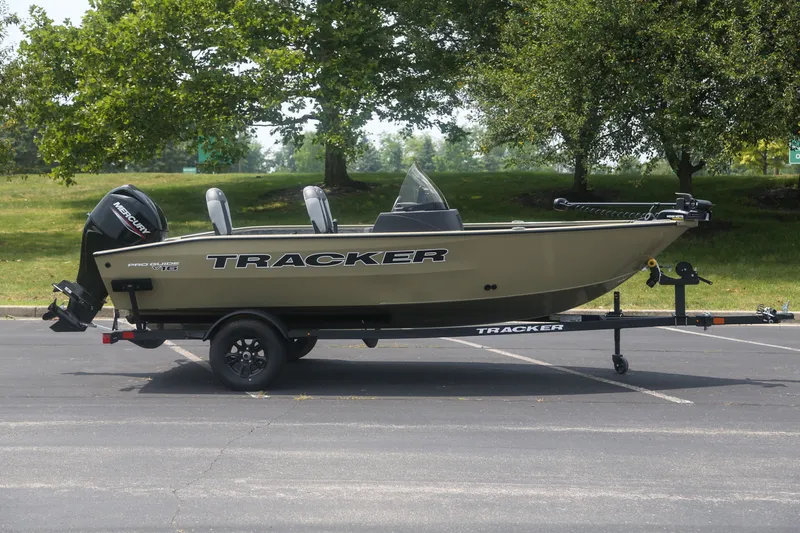 The Image of 2027 Tracker Pro Guide V-16 SC boat on trailer, parked outdoors. - 0
