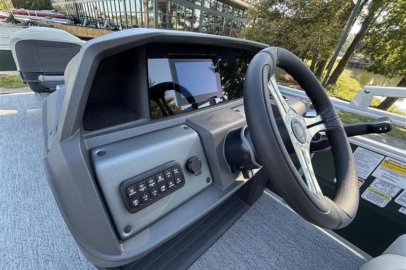Slide: The Image of 2027 Sun Tracker Fishin' Barge 20 DLX dashboard with steering wheel and control panel. - 24