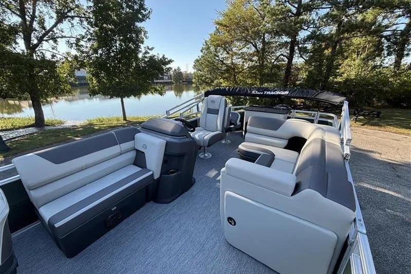 Slide: The Image of 2027 Sun Tracker Fishin' Barge 20 DLX pontoon boat with spacious seating by a serene lake. - 18