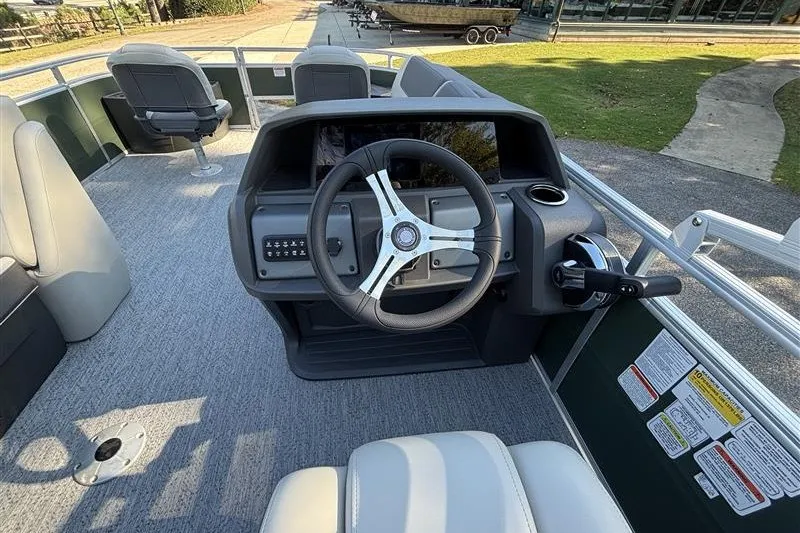 Slide: The Image of 2027 Sun Tracker Fishin' Barge 20 DLX interior with steering wheel and seating. - 22