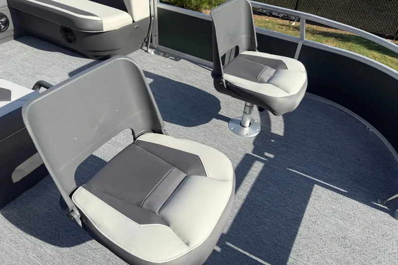 Slide: The Image of 2027 Sun Tracker Fishin' Barge 20 DLX boat seats on deck, featuring gray upholstery. - 19