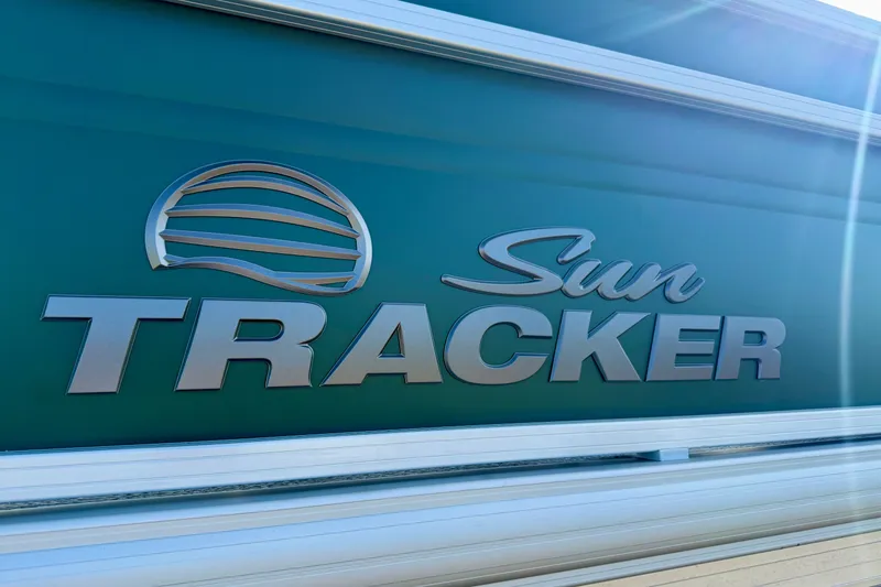 Slide: The Image of Sun Tracker Fishin' Barge 20 DLX 2027 logo on green background with sunlight. - 16