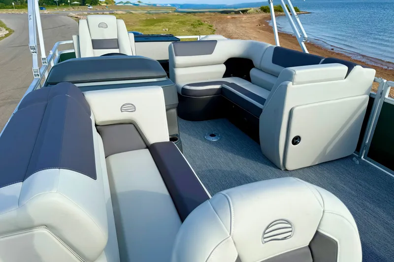 Slide: The Image of 2027 Sun Tracker Fishin' Barge 20 DLX interior with plush seating by the water. - 13