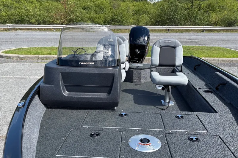 Slide: The Image of 2027 Tracker Pro Guide V-16 SC boat with seating and console, parked outdoors. - 37