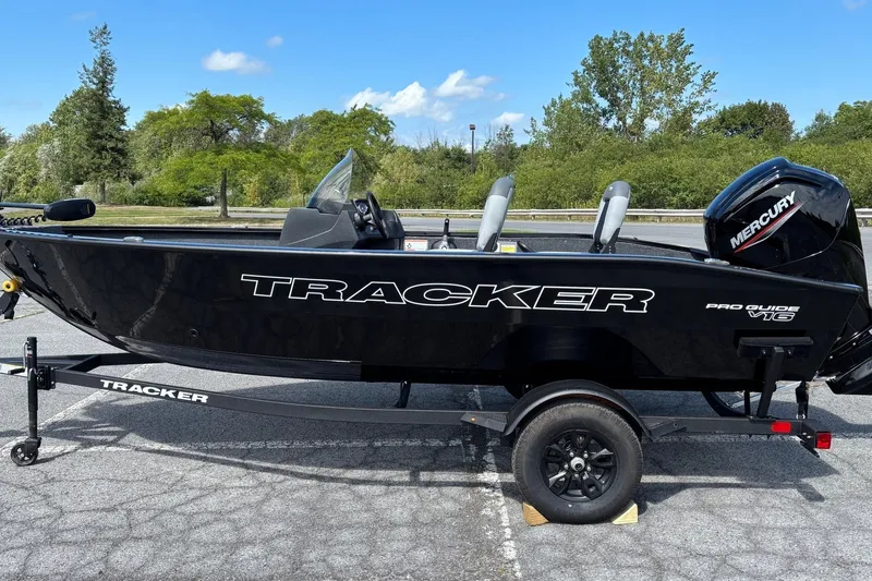 The Image of 2027 Tracker Pro Guide V-16 SC boat on trailer, parked outdoors. - 0