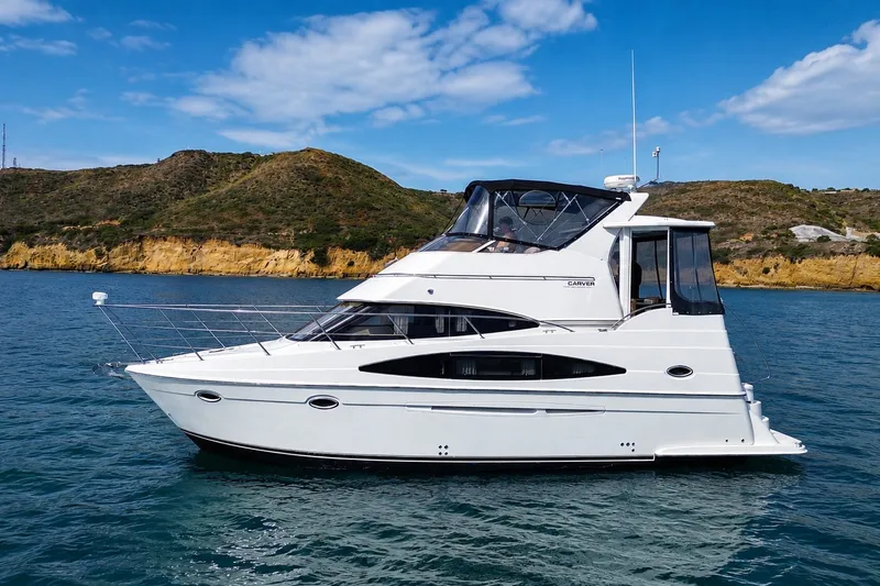 Slide: The Image of 2004 Carver 366 Motor Yacht cruising on blue water with scenic hills in the background. - 20