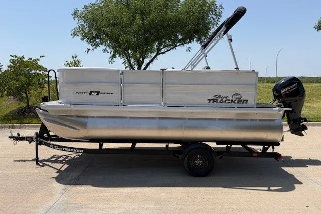 The Image of 2027 Sun Tracker Party Barge 16 DLX pontoon boat on trailer, parked outdoors. - 9
