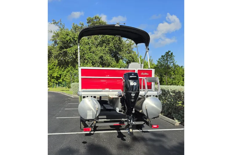 Slide: The Image of 2027 Sun Tracker Party Barge 16 DLX pontoon boat with Mercury 50 engine, parked outdoors. - 14