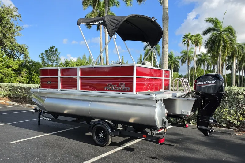 Slide: The Image of 2027 Sun Tracker Party Barge 16 DLX pontoon boat with Mercury engine in a tropical setting. - 13