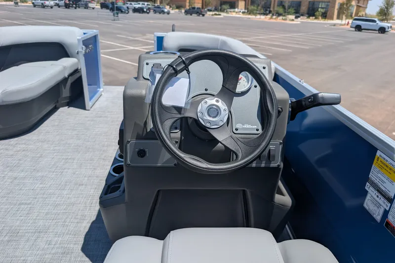Slide: The Image of Steering console of 2027 Sun Tracker Party Barge 16 DLX in a parking lot. - 12