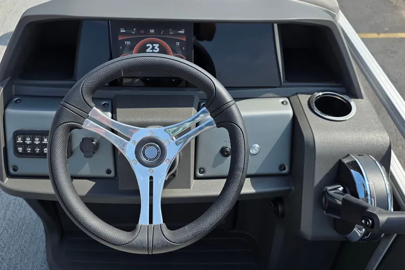 Slide: The Image of Steering console of 2027 Sun Tracker Fishin' Barge 20 DLX with modern controls and display. - 24