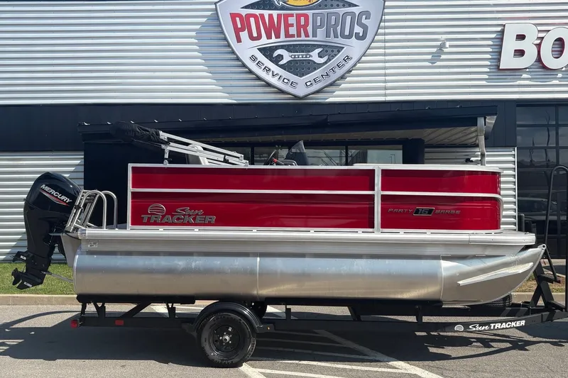 The Image of 2027 Sun Tracker Party Barge 16 DLX pontoon boat on trailer, displayed at Power Pros Service Center. - 0