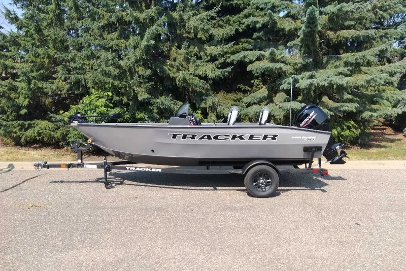 The Image of 2027 Tracker Pro Guide V-16 SC boat on trailer, parked near trees. - 0