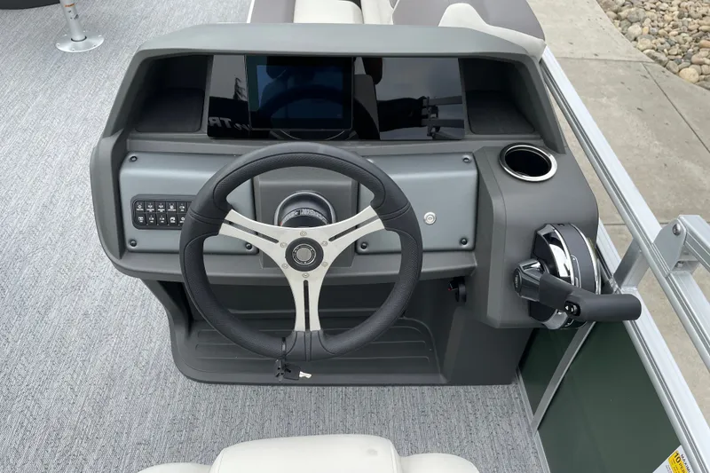 Slide: The Image of Steering console of 2027 Sun Tracker Fishin' Barge 20 DLX with modern controls and cup holder. - 14