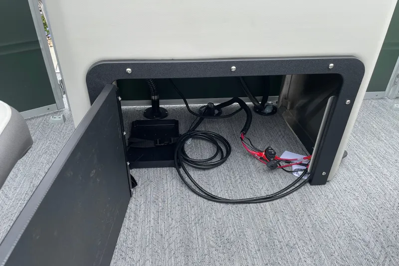 Slide: The Image of Open storage compartment with wiring in a 2027 Sun Tracker Fishin' Barge 20 DLX boat. - 21