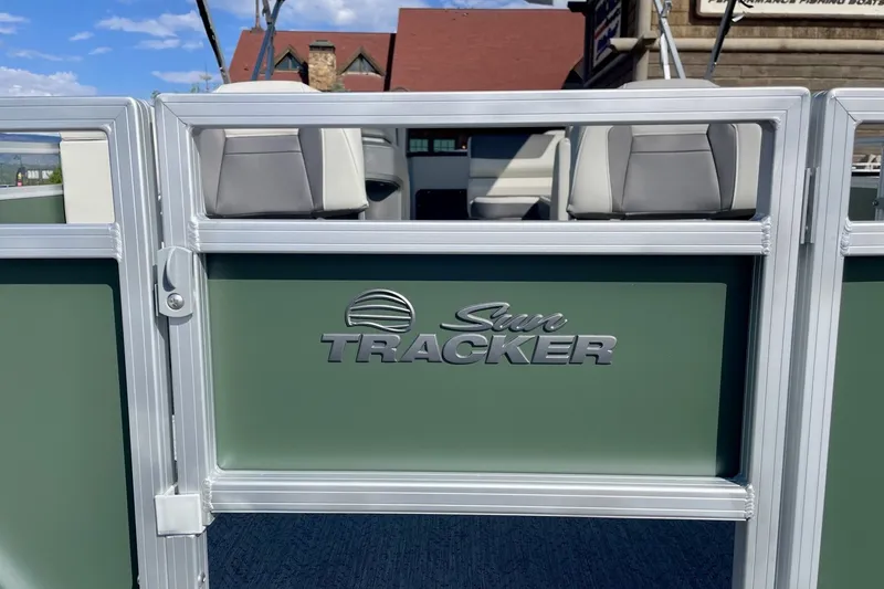 Slide: The Image of 2027 Sun Tracker Fishin' Barge 20 DLX pontoon boat with logo, green paneling, and seating. - 59