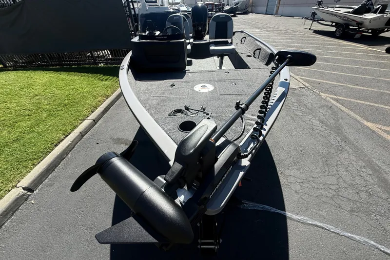 Slide: The Image of 2027 Tracker Pro Guide V-16 SC fishing boat with trolling motor on pavement. - 18