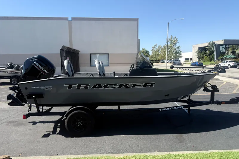 The Image of 2027 Tracker Pro Guide V-16 SC boat on trailer, parked outdoors. - 0