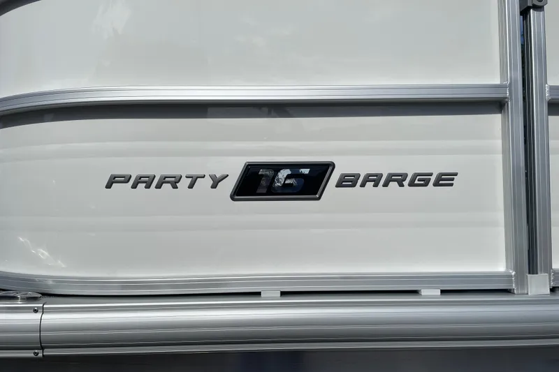 Slide: The Image of 2027 Sun Tracker Party Barge 16 DLX logo on white boat exterior. - 20