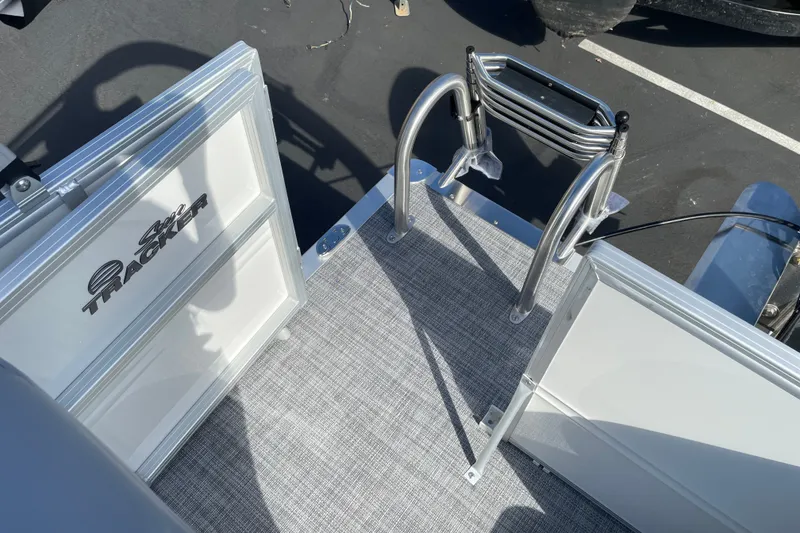 Slide: The Image of Sun Tracker Party Barge 16 DLX 2027, featuring a sturdy boarding ladder and deck. - 16