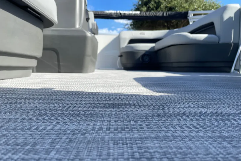 Slide: The Image of 2027 Sun Tracker Party Barge 16 DLX interior with gray flooring and seating. - 19