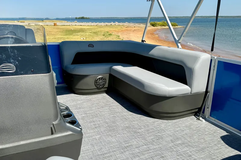 Slide: The Image of 2027 Sun Tracker Party Barge 16 DLX interior with seating, near scenic waterfront. - 14