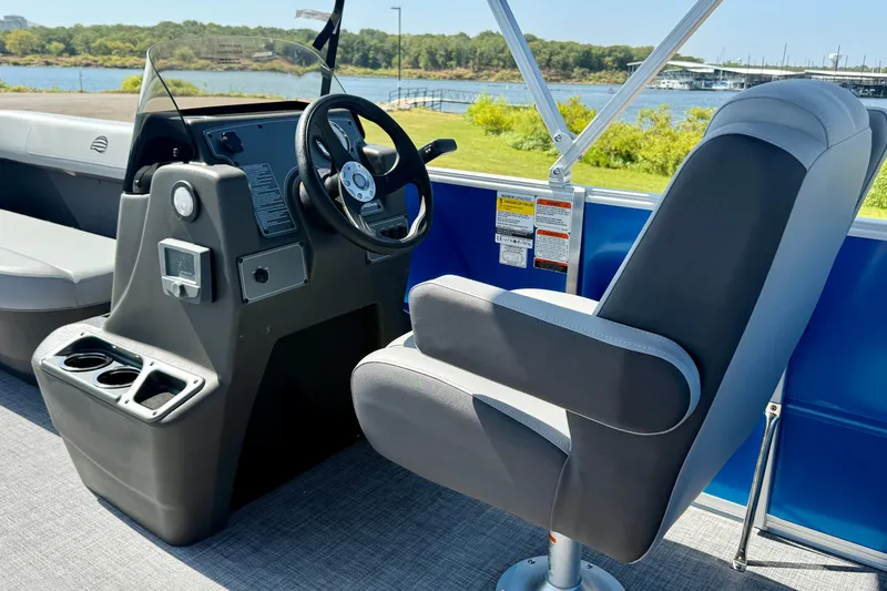 Slide: The Image of 2027 Sun Tracker Party Barge 16 DLX interior with steering console and captain's chair. - 12