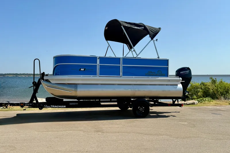 Slide: The Image of 2027 Sun Tracker Party Barge 16 DLX pontoon boat on trailer by a lake. - 15