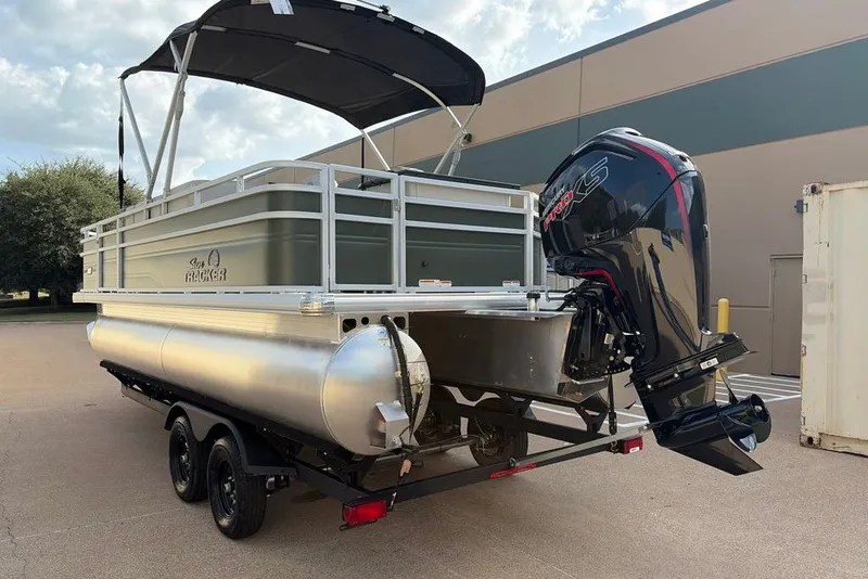 The Image of 2027 Sun Tracker Fishin' Barge 20 DLX pontoon boat with outboard motor on trailer. - 0
